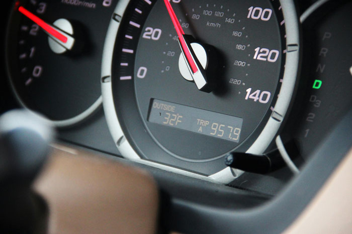 Close-up of a car speedometer and dashboard showing trip mileage and outside temperature at 32 degrees.