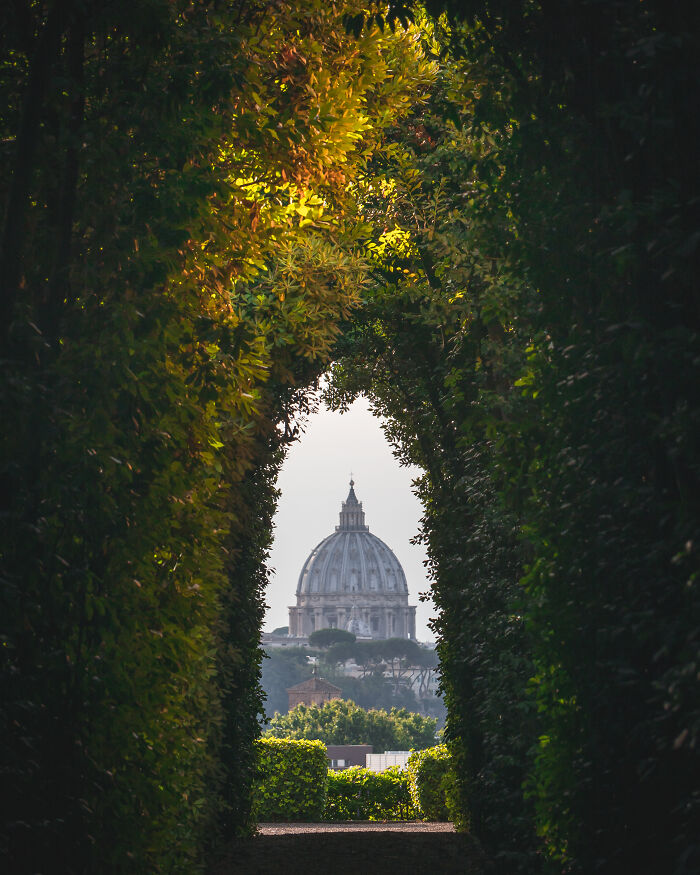 View of a historic dome framed by lush green foliage, showcasing breathtaking travel photos from the Bored Panda community.