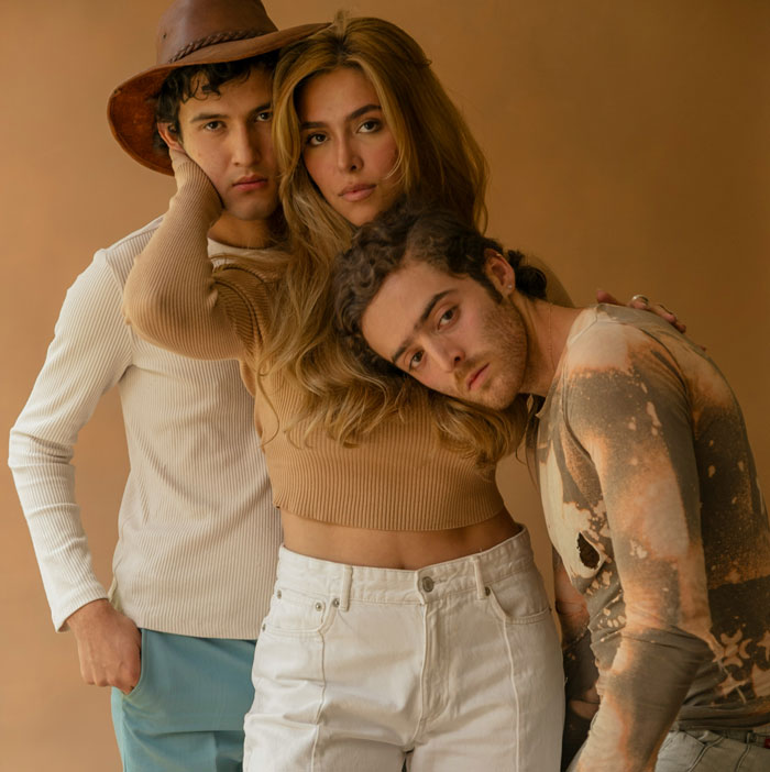 Three young adults posing closely with serious expressions highlighting toxic dating trends in a modern setting