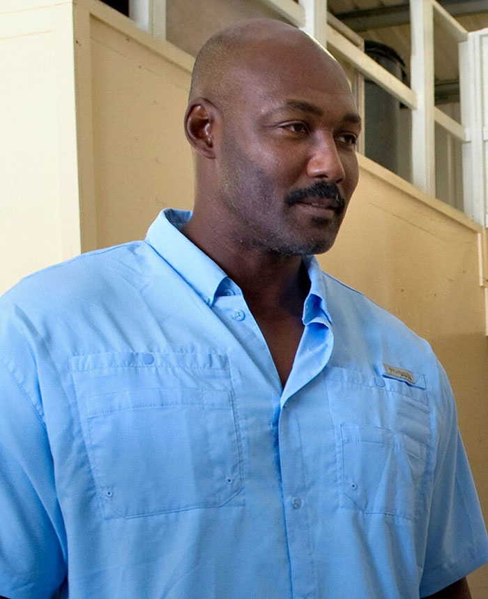 Man in a blue shirt indoors, representing famous people who did evil things but the world ignored it.