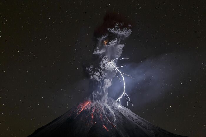 Volcanic eruption with lightning striking the night sky, a breathtaking travel photo captured by the Bored Panda community.