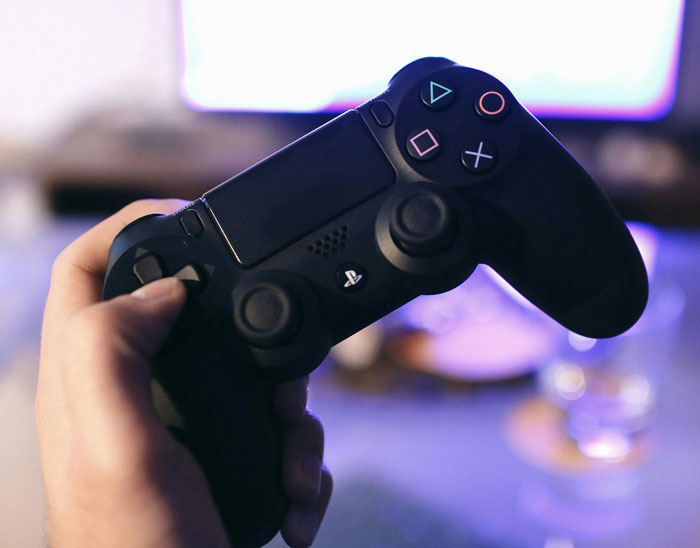 Person holding a gaming controller showing secrets on how I paid for college in a casual home setting.