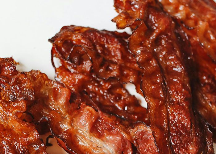 Close-up of crispy cooked bacon strips illustrating buffet workers' wildest encounters with food and customers.