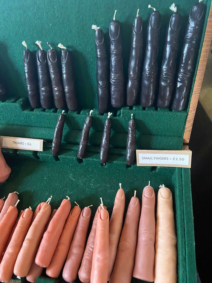 Shelf display of handmade finger-shaped candles in various sizes and skin tones, showcasing unique craft shaming DIY projects.