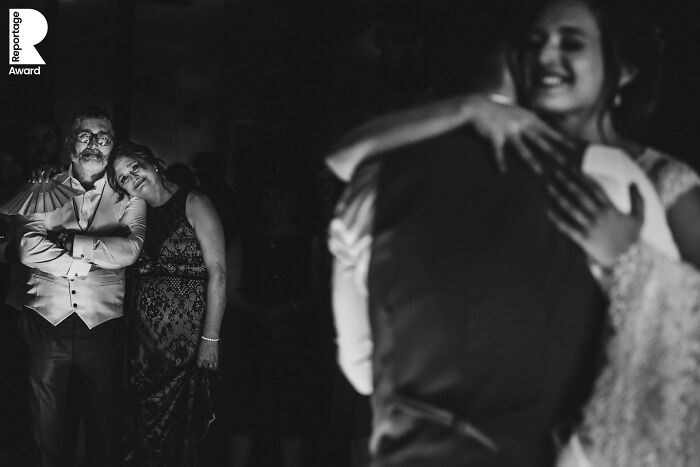 Couple sharing a dance at a wedding while guests watch, capturing an unforgettable wedding photo moment in black and white.