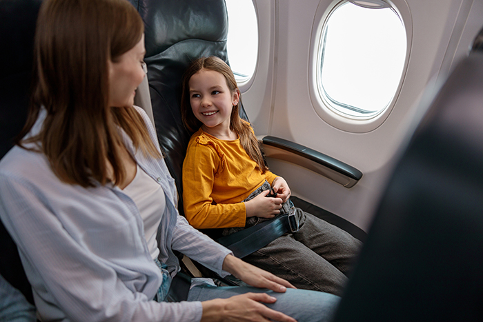 Woman and child seated on airplane near window, focusing on travel and airport situation with passport issues.