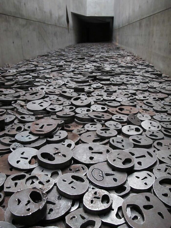 Memorial with metal faces representing victims, a powerful and fascinating historical photo conveying the past's impact.