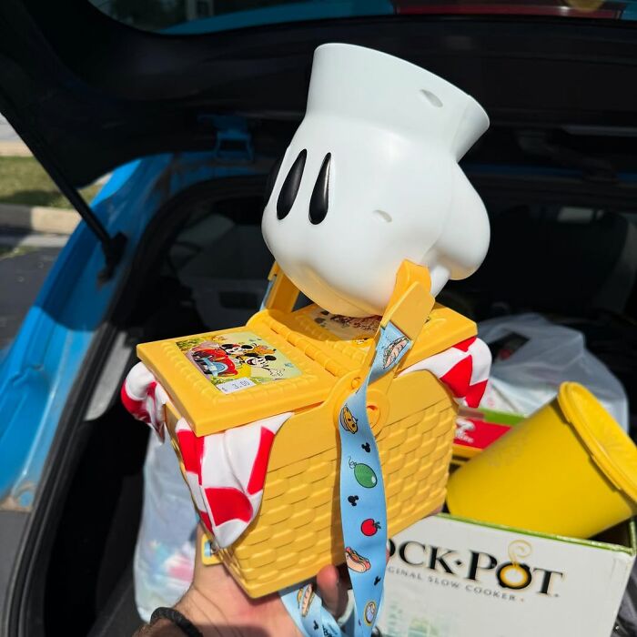 Vintage Mickey Mouse secondhand find featuring a yellow picnic basket and character hand at a car trunk sale.