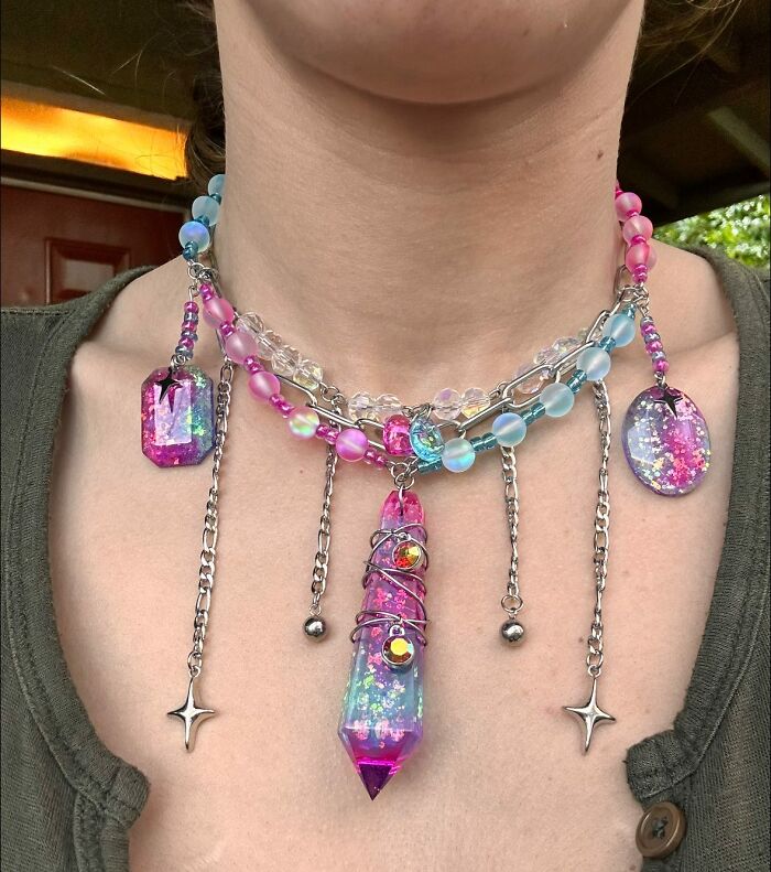 Handmade DIY craft necklace with colorful beads, glitter pendants, and metal chains showcasing unique craft shaming projects.