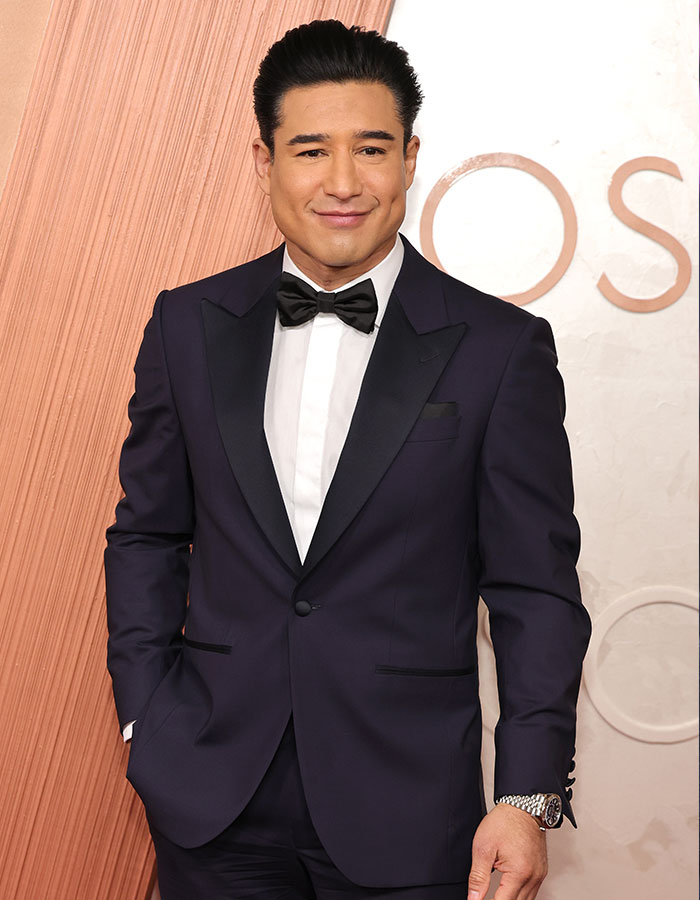 Male celebrity in a dark tuxedo smiling confidently, showcasing youthful looks among celebrities who look way younger than their age.
