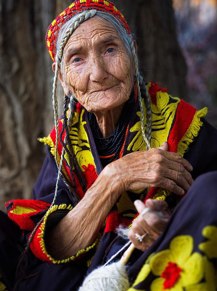 Elderly woman from around the world wearing traditional colorful clothing, showcasing timeless beauty and cultural heritage.