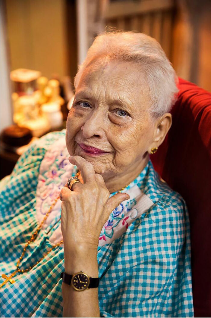 Elderly woman with white hair and blue eyes wearing a checkered blouse, showcasing timeless beauty and grace.