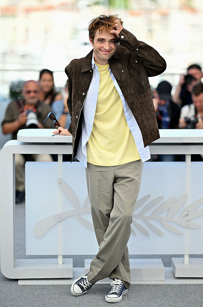 Male star posing casually in a brown jacket and sneakers, featured among stars who found new homes abroad.