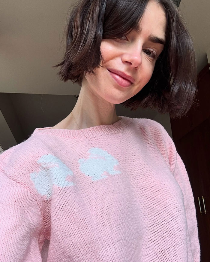 Woman in a pink sweater smiling indoors, representing stars who left Hollywood and found a new home abroad.
