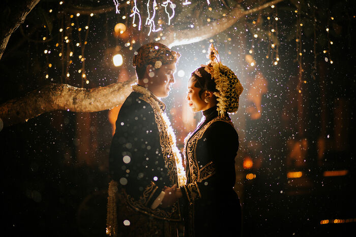 Couple in traditional wedding attire sharing a magical moment under glowing lights in unforgettable wedding photos.