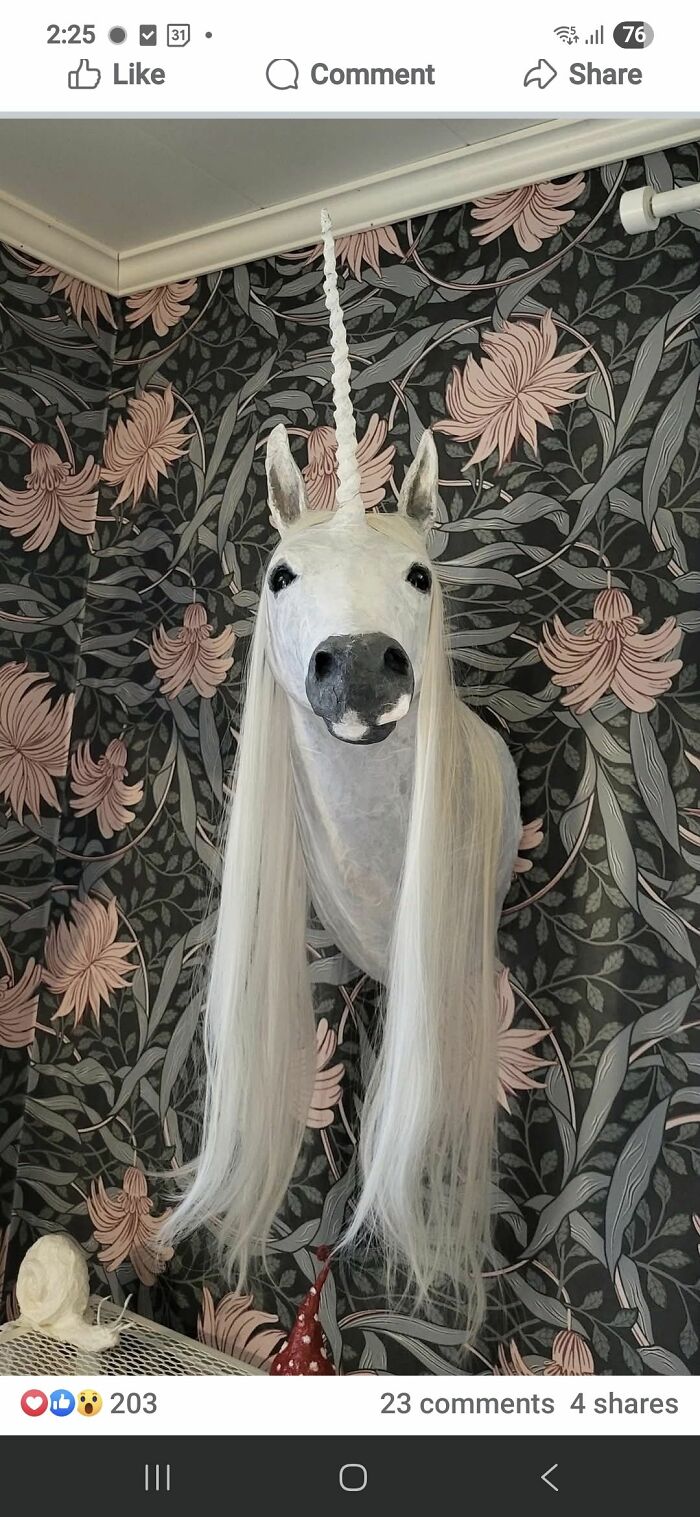 DIY craft shaming showing a poorly made unicorn head with long white hair mounted on floral wallpaper background