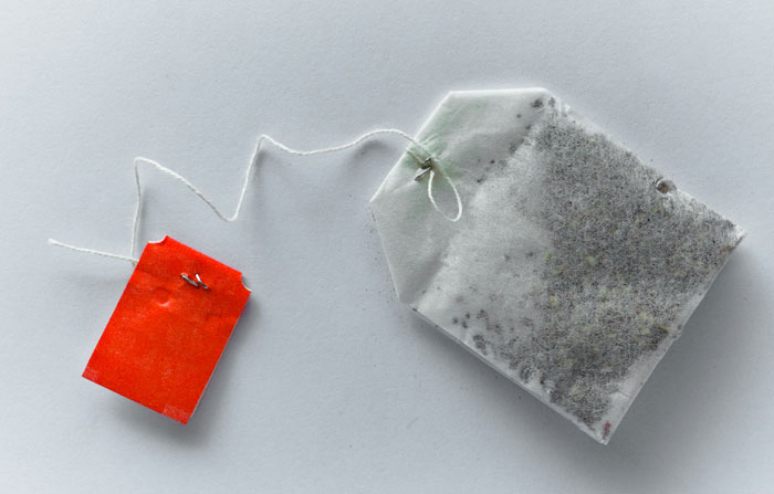 Close-up of a tea bag with a red tag, representing traditional remedies from old wives' tales and grandma's advice.