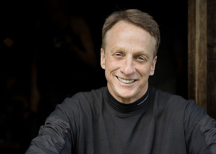 Smiling middle-aged man in a black shirt, representing celebrities before fame found them in a casual setting.