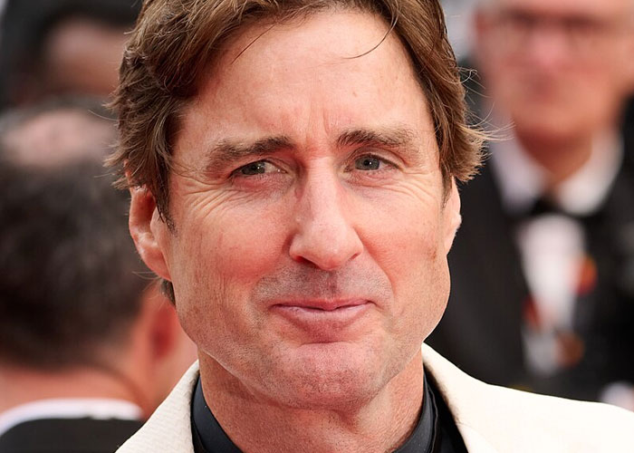 Close-up of a smiling celebrity at a formal event, illustrating what celebrities were doing before fame found them.