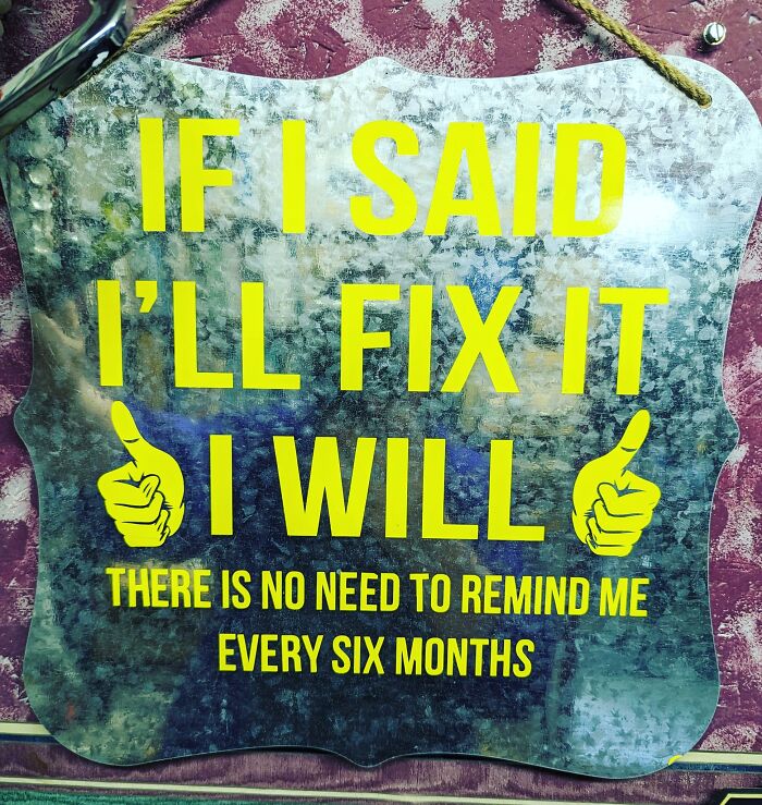 Metal sign with yellow text and thumbs up icons humorously addressing DIY project delays in a craft shaming context.