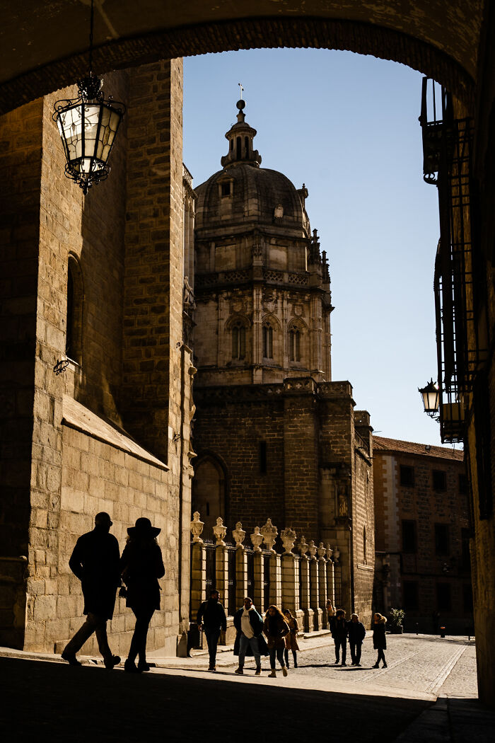 Historic European street with ancient architecture and people walking, showcasing breathtaking travel scenes captured by the community.