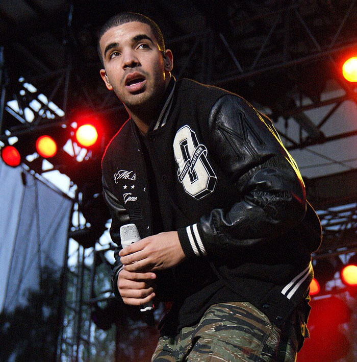 Famous person performing on stage wearing a black jacket and camo pants, related to famous people who did evil things.