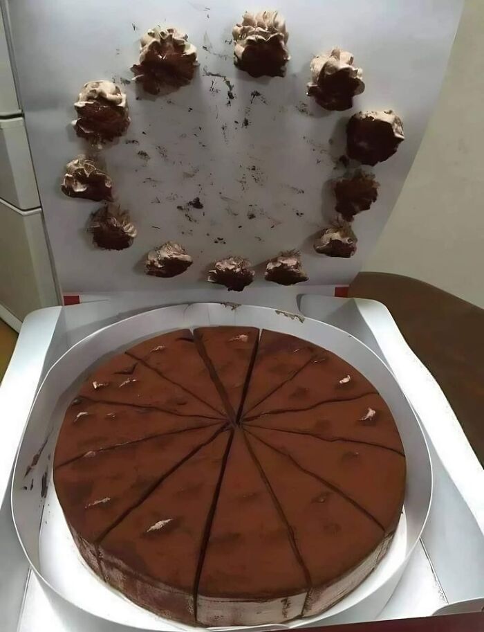 Chocolate cake with unevenly placed frosting dollops on the box lid, a cursed picture of food that might make you go eeeeuw