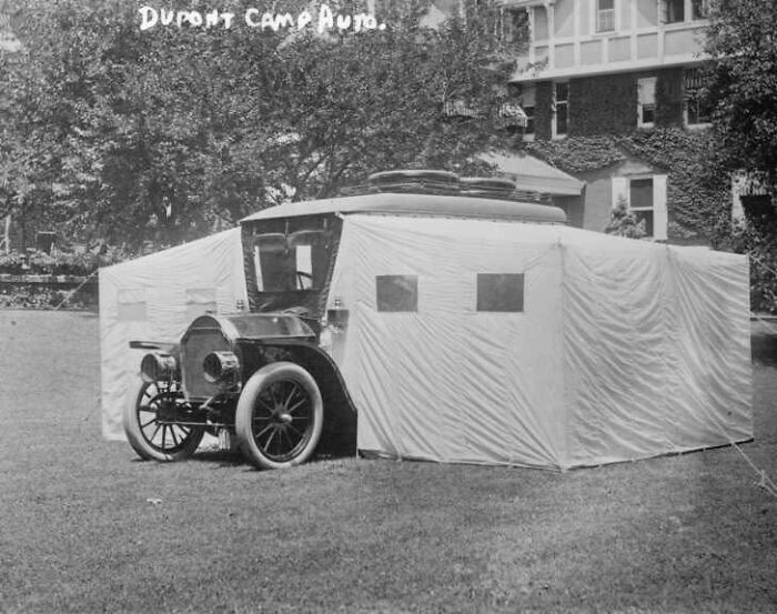 Early 20th-century car with an attached canvas tent at Dupont Camp Audio, showcasing historical inventions.