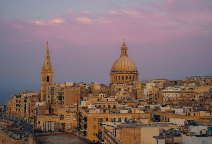 Sunset cityscape travel photo showing historic buildings with domes and spires, showcasing breathtaking travel photography.