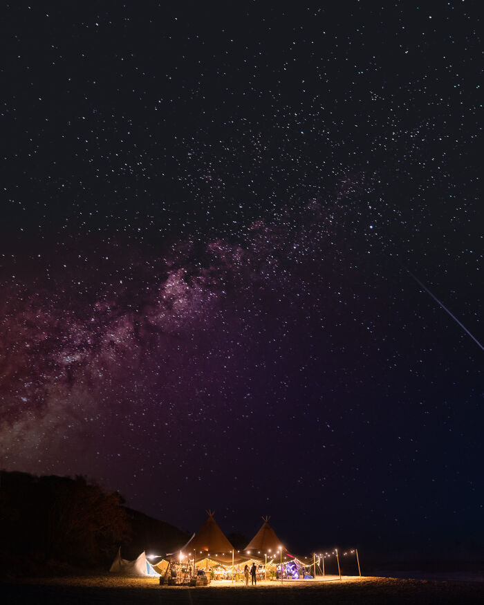 Nighttime wedding celebration under a starry sky with tents and string lights creating an unforgettable wedding photo scene.