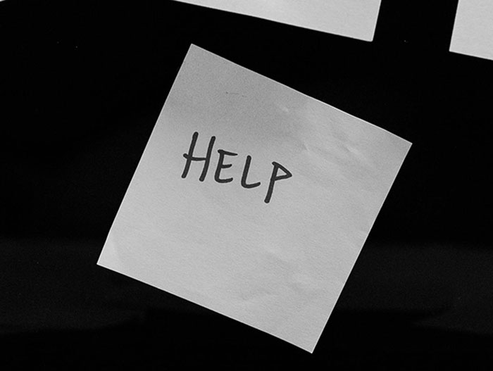 Sticky note with the word help written on it symbolizing captive woman's brave cry for help in Jersey Mike's restroom.