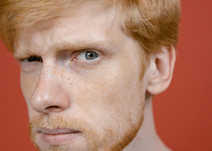 Close-up of a red-haired dad with freckles sharing his honest expression about the birthing room experience for the first time.