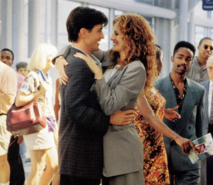 Couple embracing in a crowd, representing romantic movies that are considered toxic instead of healthy love.