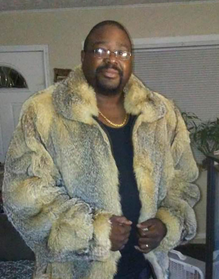 Man wearing a large fur coat and glasses standing indoors, related to marriage isn't easy viral explanation story.