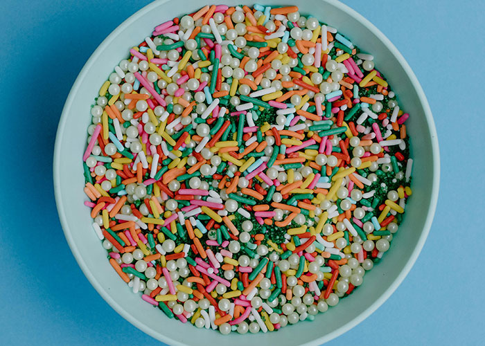 Bowl filled with colorful sprinkles resembling a wild buffet encounter shared by buffet workers in vibrant detail.