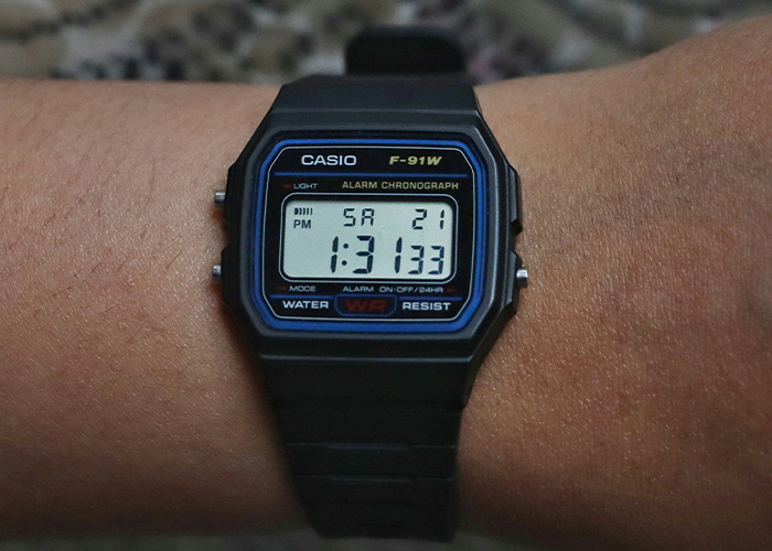 Casio F-91W digital watch on wrist, a popular obsolete item still used daily by 60 people with no shame.