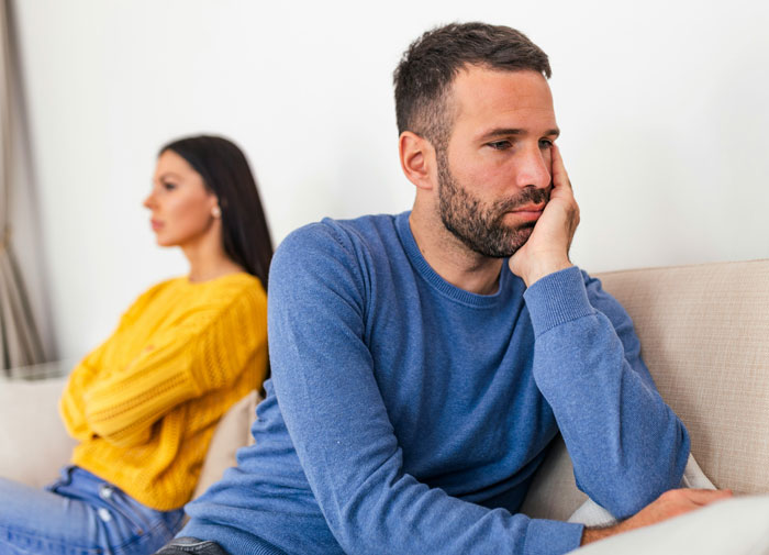 Man and woman sitting apart looking upset, illustrating emotional moments and insane revelations people had in therapy sessions.