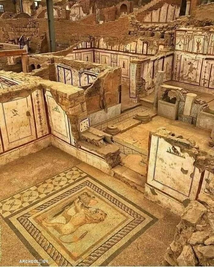 Ancient archaeological site with detailed mosaics and mural paintings showcasing historical art and architecture.