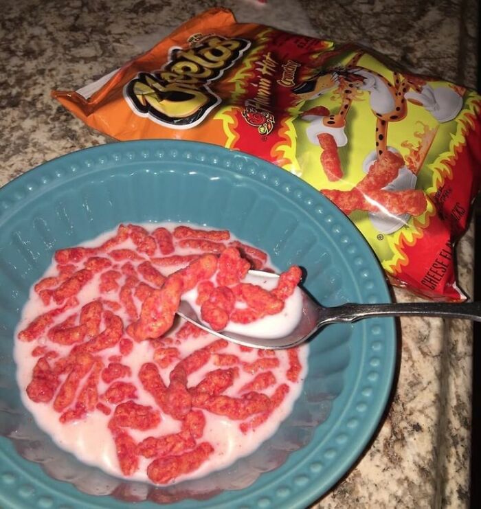 Bowl of hot Cheetos with milk being eaten with a spoon, showing cursed pictures of food that might disgust viewers.