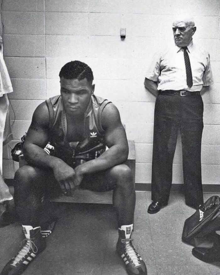 Historic photo of a focused boxer resting before a match, capturing a powerful moment from the past.
