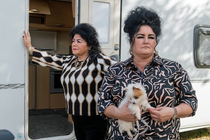 Two women with bold hairstyles standing outside a caravan, illustrating life on the margins of modern Ireland.