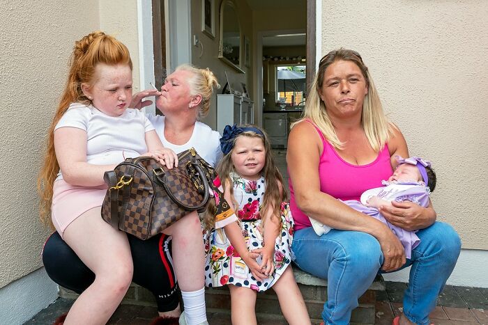 Family sitting outside their home, capturing raw and beautiful photos showing life on the margins of modern Ireland.