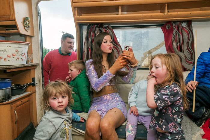 A young woman and children inside a caravan, capturing candid moments showing life on the margins of modern Ireland.