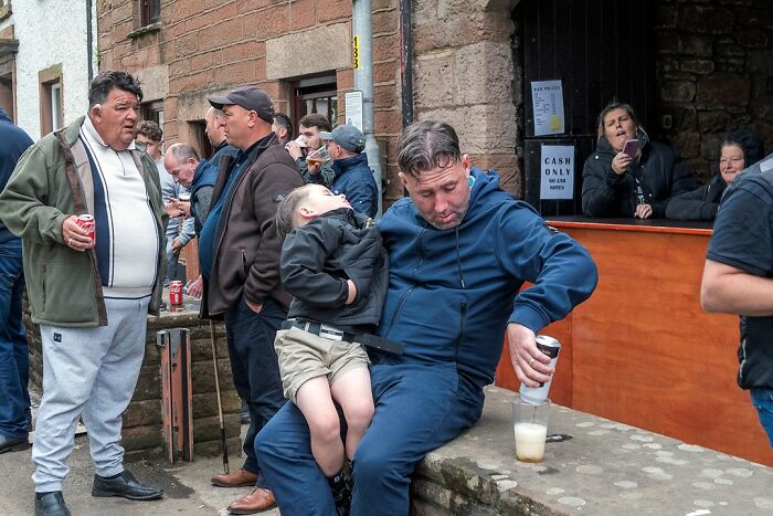 Group of people socializing outdoors, capturing raw and beautiful life on the margins of modern Ireland street scene.