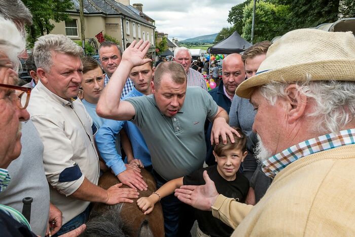 Group of people interacting outdoors during a community event in modern Ireland, illustrating life on the margins.