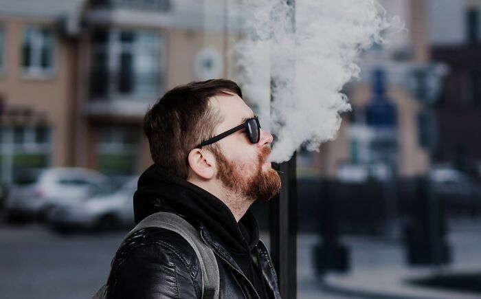 Man wearing sunglasses and a leather jacket vaping outdoors illustrating European netizens correcting common country misconceptions.