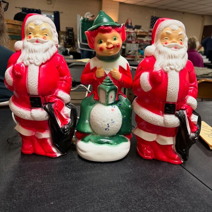 Vintage ceramic Santa figurines and an elf lamp, cool secondhand finds displayed on a table at a market.