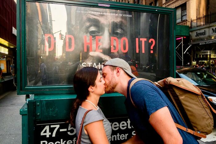 Couple kissing on a busy city street captured by street photographer catching candid world moments.