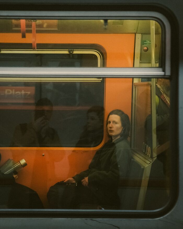 Urban photo of a woman on a train seat, captured by Helsinki-based photographer in a real street moment.