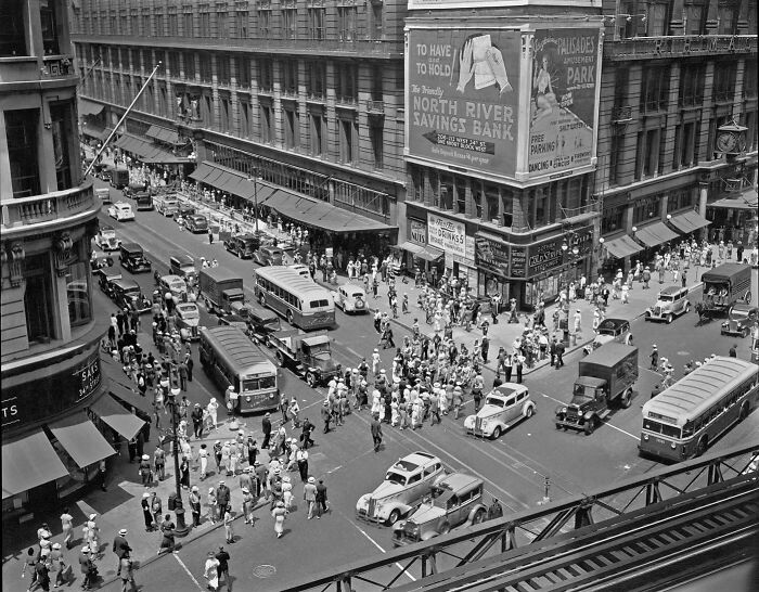Colorized historical photo showing a busy city intersection with vintage cars and crowds in a magical scene